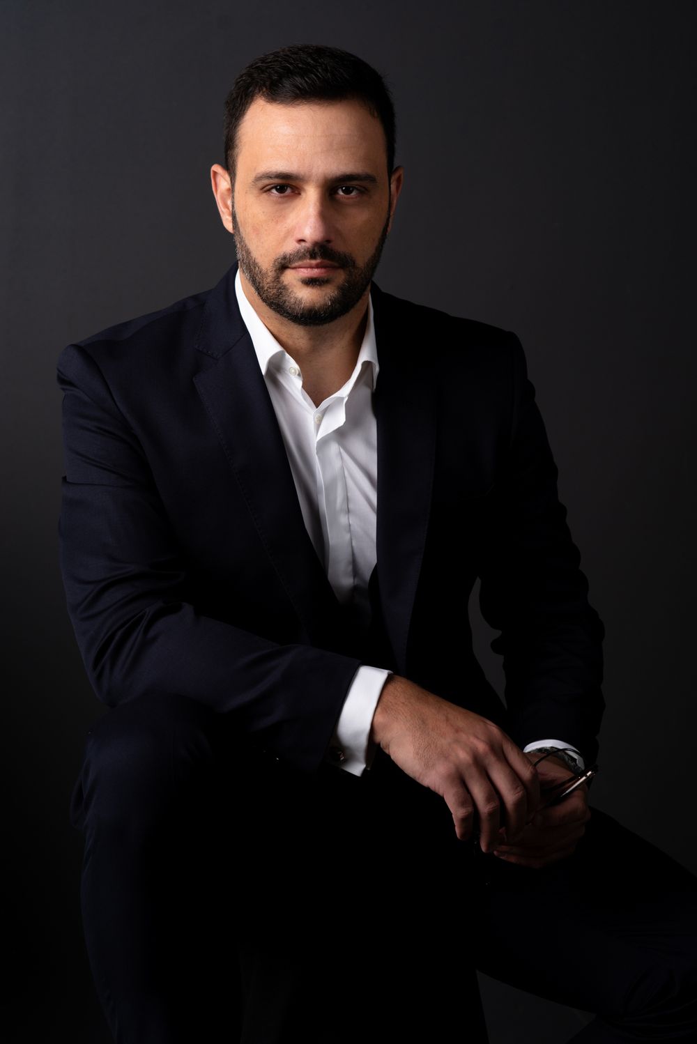 Ismael Santos, de terno escuro, olhando para a câmera