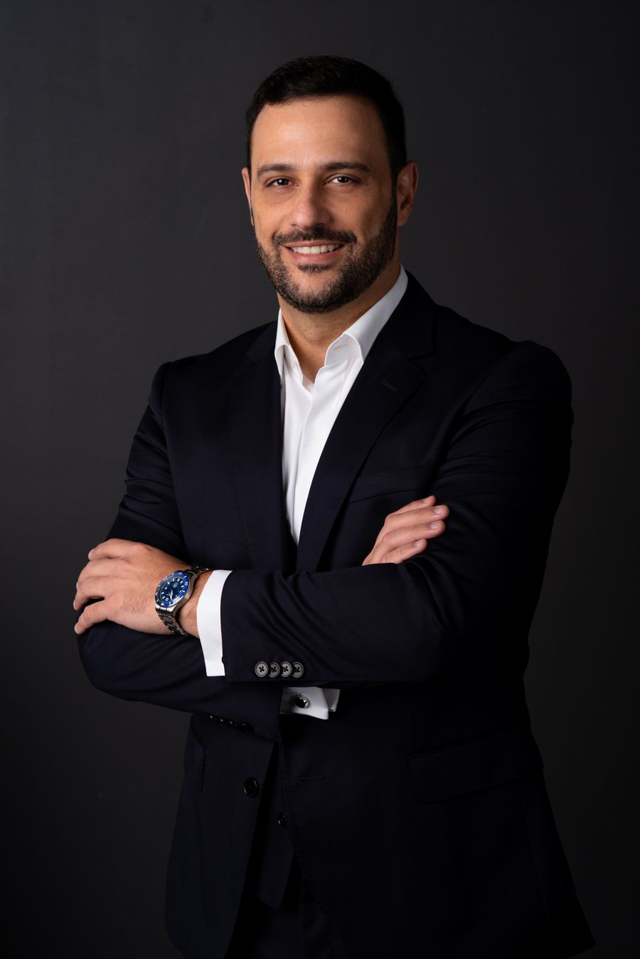 Ismael Santos sorrindo, de braços cruzados
